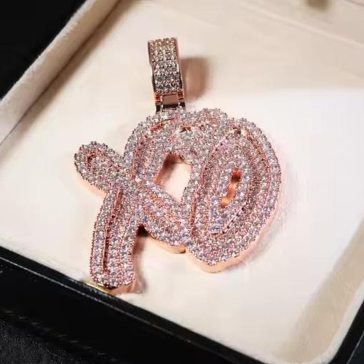 Rose gold pendant with gemstones on a white background
